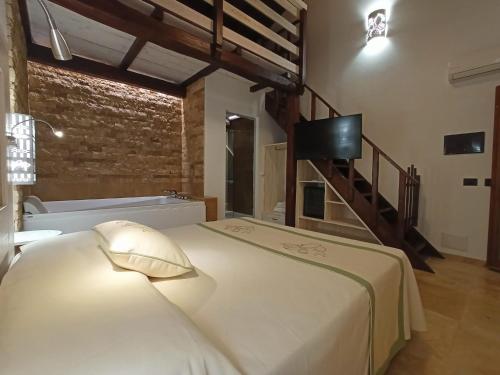 康特港Agriturismo Porticciolo的卧室配有一张床铺,墙上配有电视