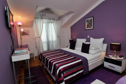 察夫塔特Hotel Haus Am Meer Cavtat的一间卧室配有一张大床和紫色墙壁