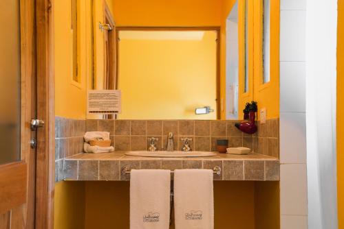 特来凡林查尔华库恩小屋酒店的浴室配有盥洗盆、镜子和毛巾