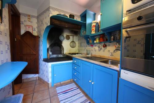 莫尼兹港Casa do Ribeirinho的蓝色的厨房,配有蓝色的橱柜和水槽