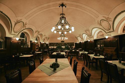 阿本斯贝格Brauereigasthof zum Kuchlbauer的一间带桌椅和吊灯的用餐室