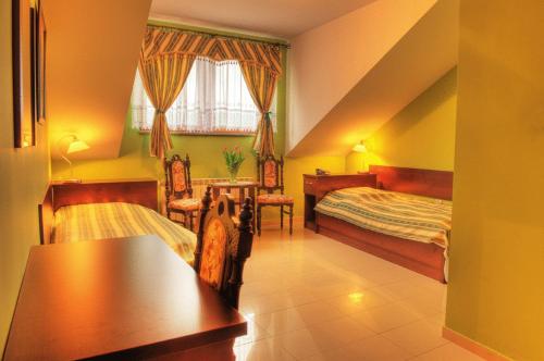 Bieruń Nowy阿德里亚旅馆的一间卧室配有两张床和一张桌子及椅子