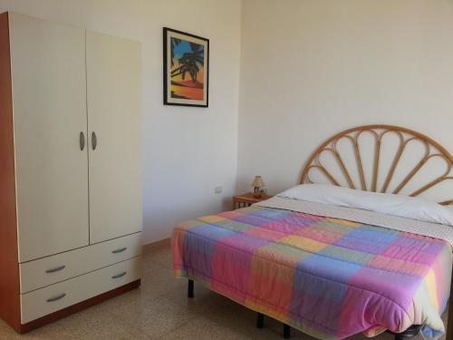 普雷西切Residence Il Giunco的一间卧室配有一张床和一个梳妆台