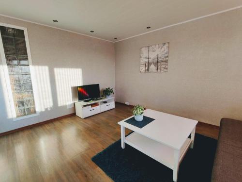 基维厄利Kotkapesa Apartment的客厅配有白色桌子和电视