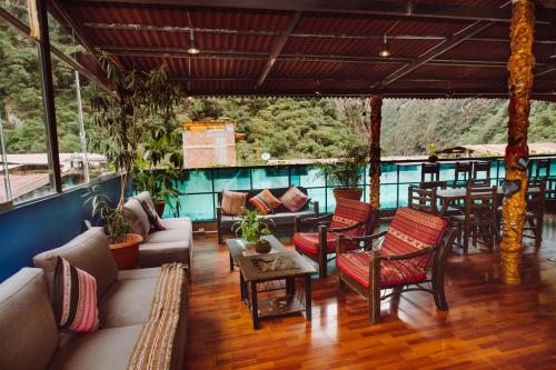 马丘比丘Nativus Hostel Machu Picchu的客厅配有家具和桌子