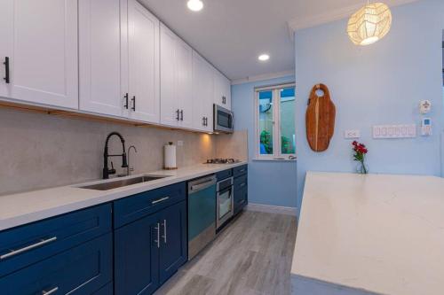 拿骚Harbour Mews - Oceanfront Townhouse的厨房配有蓝白色橱柜和水槽