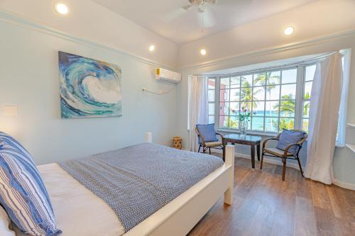 拿骚Sunshine Studio at Viking Hill - Love Beach的一间卧室配有一张床、一张书桌和一个窗户。