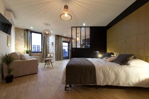 卢昂Appart Hotel Eugenie的一间卧室配有一张大床和一张沙发