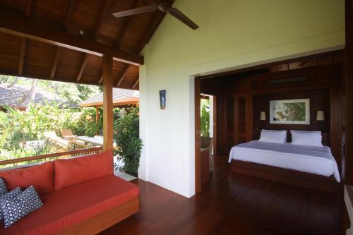 BejucoCanta La Rana的一间卧室配有一张床和一张沙发