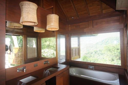 BejucoCanta La Rana的带浴缸和水槽的浴室以及2扇窗户。
