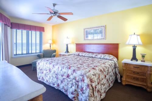 彭萨科拉海滩Soundside Holiday Beach Resort的酒店客房配有一张床和吊扇。