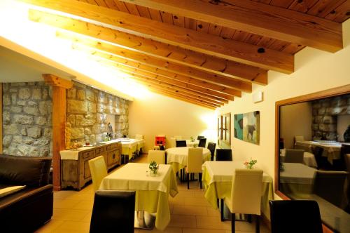 塞尔塞迪利亚如拉拉斯罗兹艾拉斯酒店的一间设有白色桌椅和石墙的餐厅