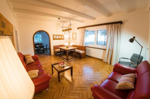 Ravne na KoroškemVila Park Ravne的客厅配有红色的沙发和桌子
