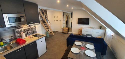 多维尔Le Deauvillais - Appartement Plein Centre - 4 pers - 2 mn plage - Idéal Famille的厨房以及带桌椅的起居室。