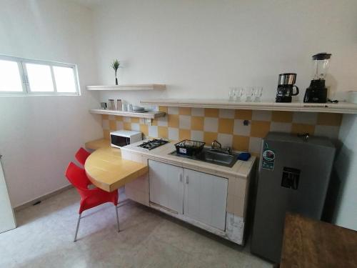 科利马Htl & Suites Neruda, ubicación, limpieza, facturamos的一间带桌子和冰箱的小厨房