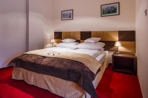 罗兹II号精品酒店的卧室配有一张带白色床单和枕头的大床。