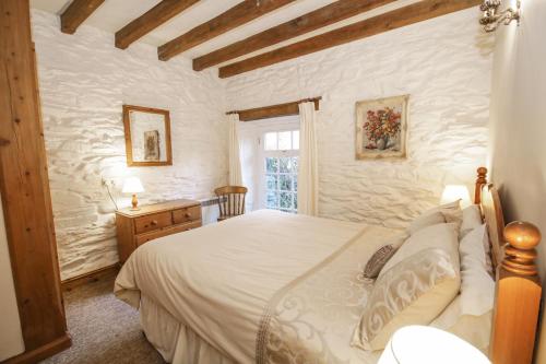 贝图瑟科伊德Royal Oak Farm Cottage的一间卧室设有一张大床和一个窗户。