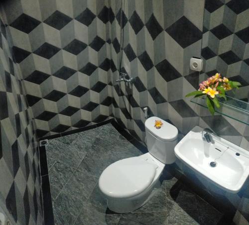 茂物Rion Hostel Bogor的浴室配有白色卫生间和盥洗盆。