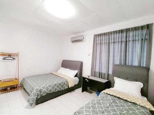 怡保SS Ipoh Comfort Homestay - For Families and Groups的酒店客房设有两张床和窗户。