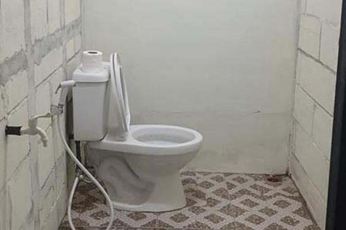 Sungai LutusRocky Guest House Syariah Mitra RedDoorz的一间带卫生间和软管的浴室