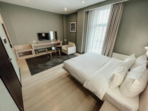 阿拉木图Resident City Hotel的卧室配有白色的床和书桌