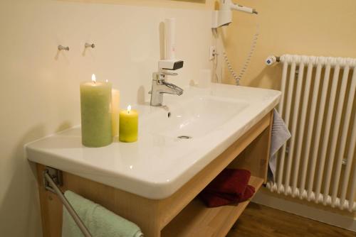 比赫莱尔塔尔Appartementhotel Breitmattstub的浴室设有水槽和两根蜡烛
