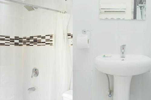拉各斯Mariners Suites Lagos的白色的浴室设有水槽和淋浴。