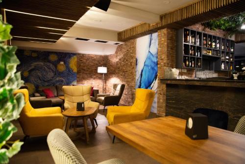 科查尼Hotel City IN的一间设有黄色椅子的餐厅和一间酒吧