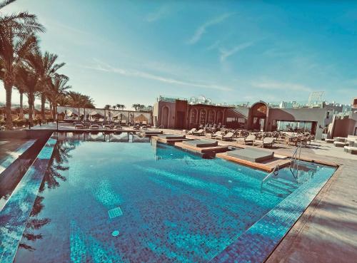 赫尔格达Sunrise Tucana Resort Grand Select-的一个带躺椅的大型游泳池,度假村