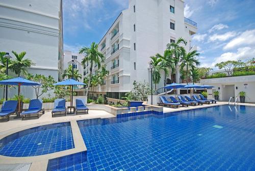 暹粒塔拉吴哥酒店的酒店游泳池设有蓝色椅子和遮阳伞