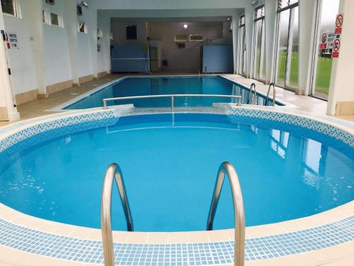比迪福德Glade Lodge- North Devon Coast, Bideford Bay Caravan Park的一座蓝色的医院大楼里的一个大型游泳池