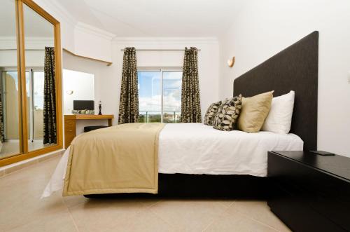 拉戈斯Fairviews Villa on Boavista Golf Resort的一间卧室设有一张大床和大窗户