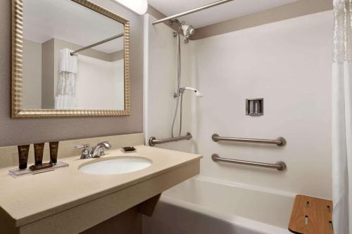 布里奇波特Wingate by Wyndham Bridgeport Clarksburg的一间带水槽、浴缸和镜子的浴室
