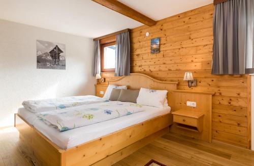 贝旺楚格峰美景酒店的卧室配有木墙内的一张床