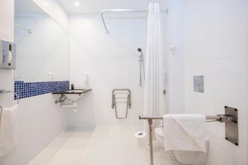 格拉诺列尔斯Holiday Inn Express Barcelona - Montmeló, an IHG Hotel的带淋浴和盥洗盆的白色浴室