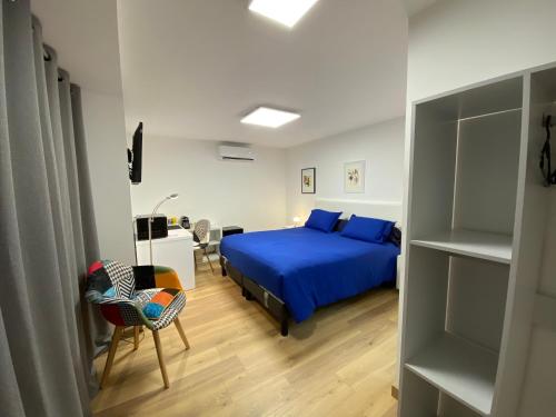 福梅尔Chambre d'hôtes indépendante de Pouzatel的一间卧室配有蓝色的床和一张书桌