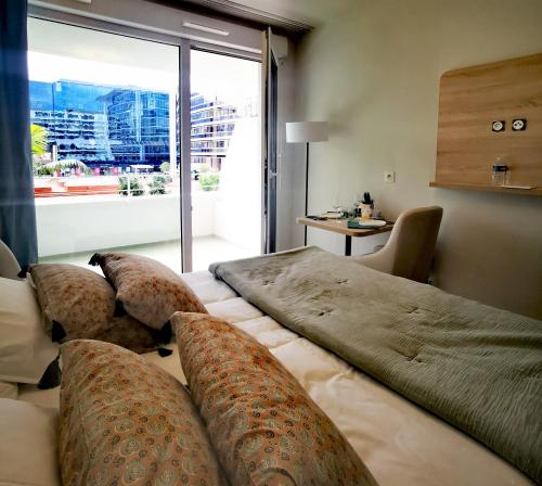 尼斯Residhome Nice Aéroport的酒店客房设有两张床和大窗户。