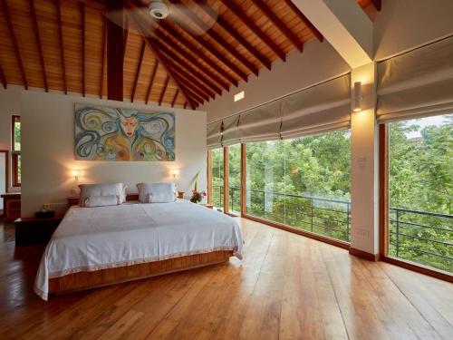 迪加纳The Glasshouse Victoria Villa, Kandy的一间卧室设有一张大床和大窗户