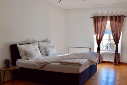 格莱斯多夫Golf-Appartement的配有窗户的客房内的一张带白色床单和枕头的床