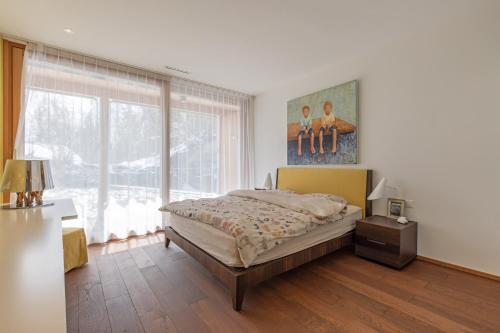 弗利姆斯Edelweiss Mountain Suites 04-05的一间卧室设有一张床和一个大窗户