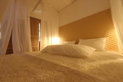 南希Le cocon aux portes de la place Stanislas的卧室内的一张带白色床单和枕头的床