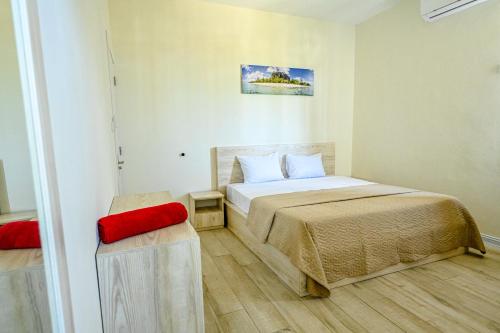 格兰贝伊New Villa Geranium的一间小卧室,配有一张床和一把红色椅子