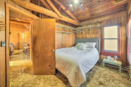 CornellCornell Home with Fire Pit and Hunting Access!的卧室配有一张床铺,位于带木墙的房间内