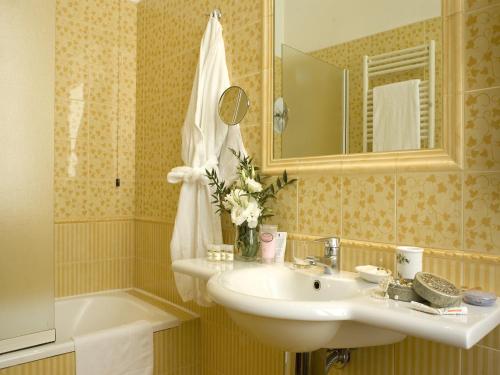 罗马亚伯丁酒店的浴室配有盥洗盆、镜子和浴缸