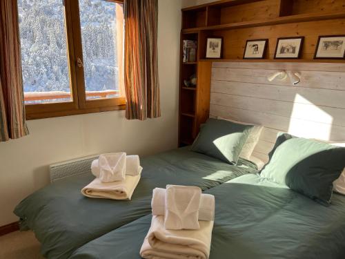 莱斯奥琉斯Le CAPRICORNE OLYMPIE 3的一间卧室配有两张带毛巾的床