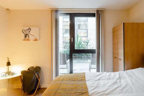 伯明翰Spacious 1 bed Apartment with workspace, Coffee & FREE Parking的一间卧室设有一张床和一个滑动玻璃门