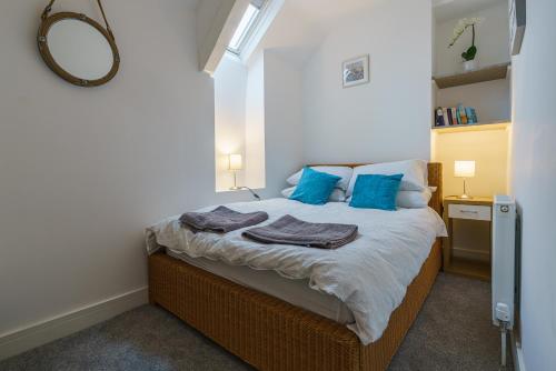 赛伦塞斯特Private deck with newly refurbished flat attached!的一间卧室配有一张带蓝色枕头和镜子的床