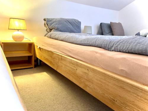 库尔维瓦旅舍 的一间卧室配有一张木床和一张桌子上的台灯