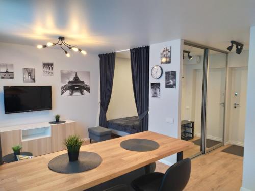 阿利图斯Studija Alytuje的客厅配有木桌和电视。