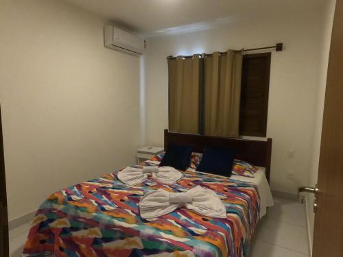 巴拉多库努Apartamento em Barra do Cunhaú的一间卧室,配有一张床,床上有一个弓